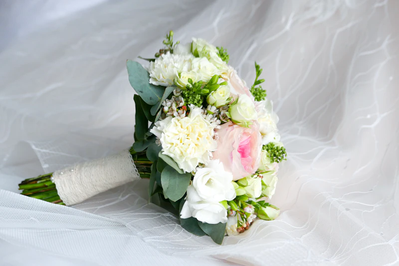A bouquet of white and pink flowers resting on white fabric