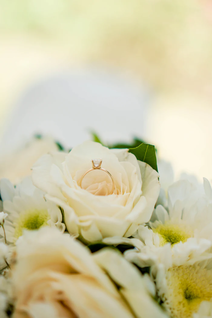 White roses with a gold ring resting in the center