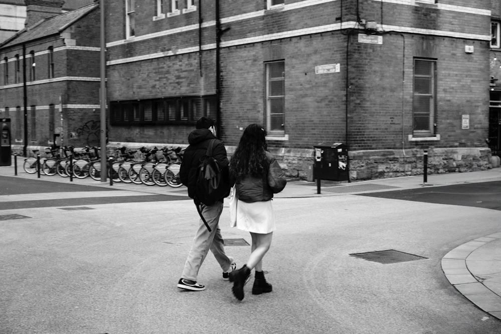 A couple walking away down a city street, in black and white